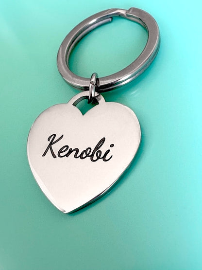 Heart-shaped keychain with a name engraving on a light blue background